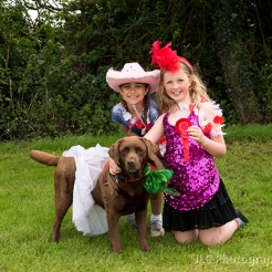 Two girls and a dog in fancy dress at Somersham Carnival 2014 Novelty Dog Show.